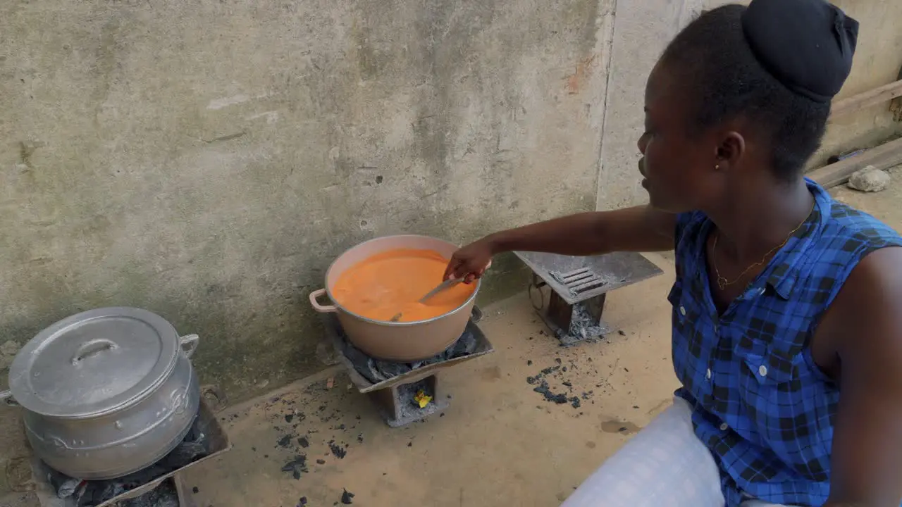 Fufu is a pounded meal found in West African cuisine close up of black ghanese woman preparing the food in pot in the street