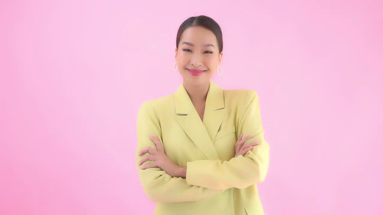 A young businesswoman in a pastel yellow suit has a positive confident attitude