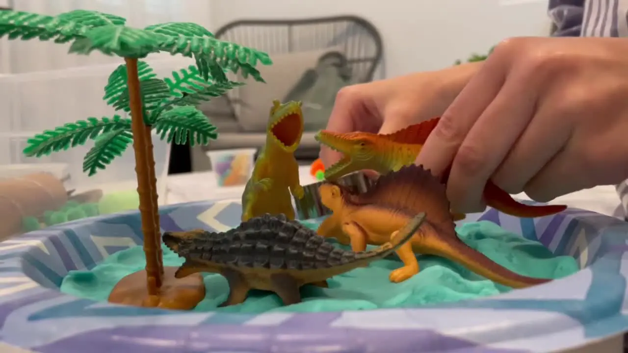 Child playing with mini toy dinosaur figures