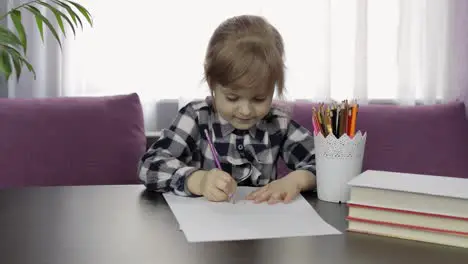 Cute child girl studying drawing picture with pencil at home Distance education