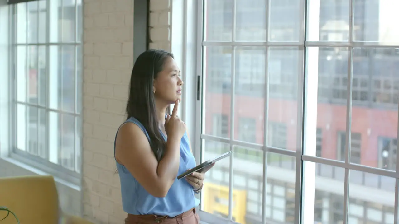 Biracial woman ponders a business problem in a bright office