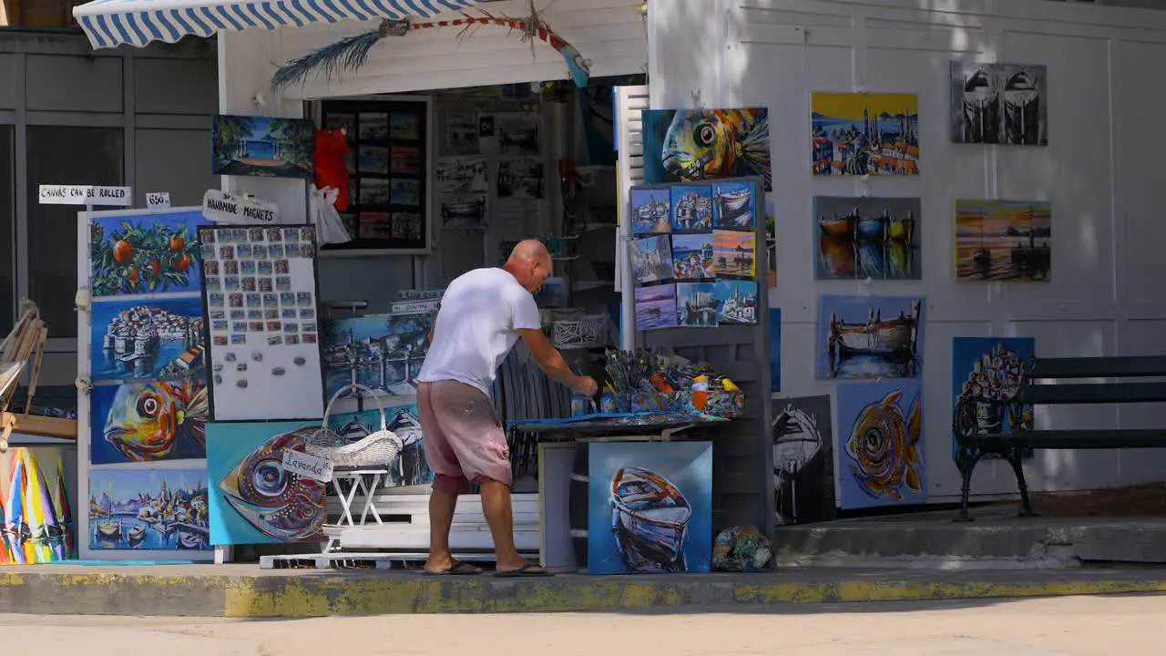 Local artist painting outside of his art shop in Croatia