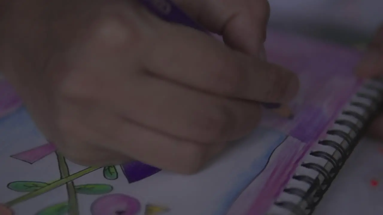 A close up shot of a hand coloring in a drawing