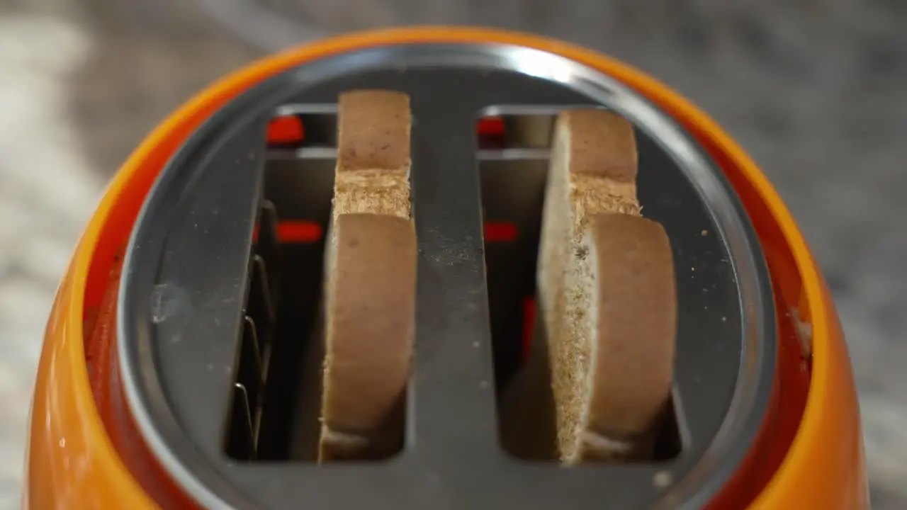 Close-up of two pieces of bread toast popping up in a toaster