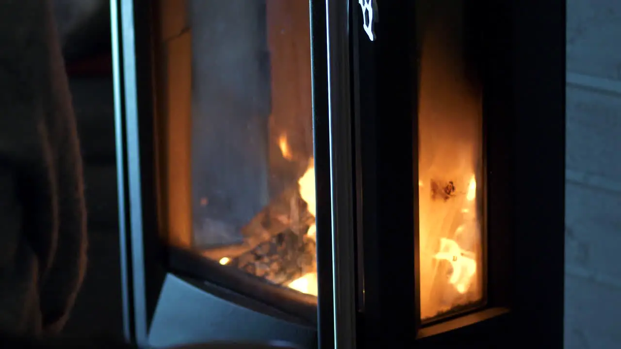 Close slomo tilt down of fire in modern wood burning stove indoors