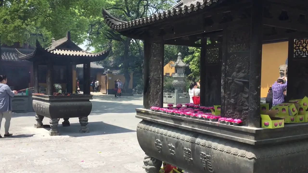 People praying with burning incenses and candles at Longhua Temple in Shanghai China