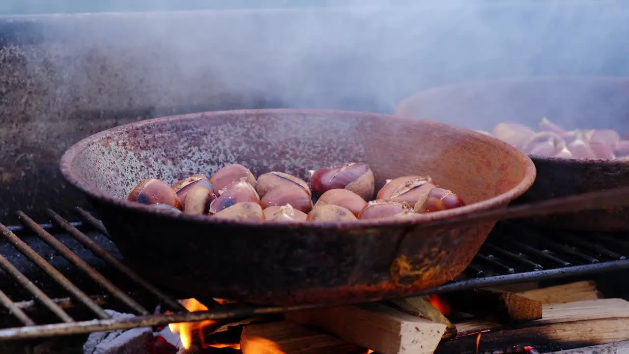 Chestnuts cooked roasted in pan over fire traditional rustic dessert