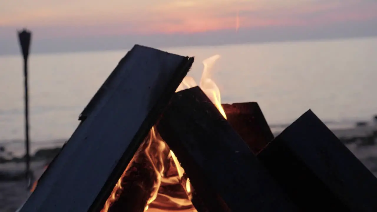 Bonfire by the beach at sunset in Asia ultra slow motion panning right