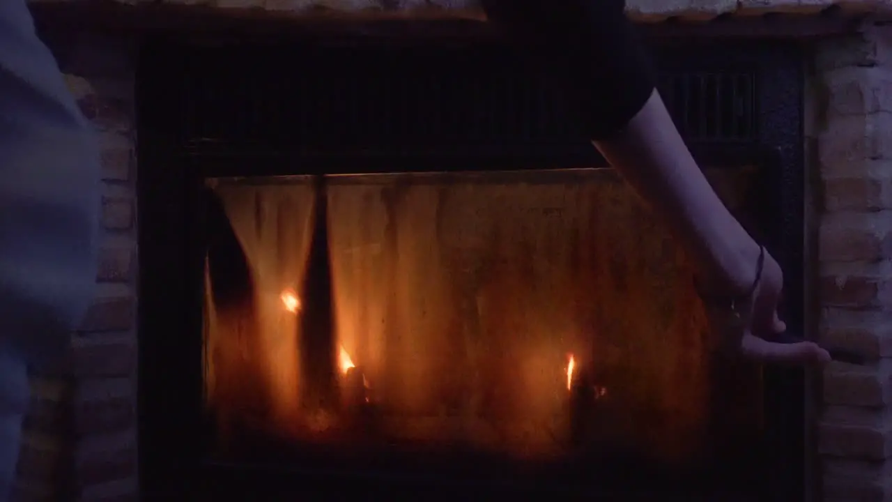 Man opening the window of a fireplace