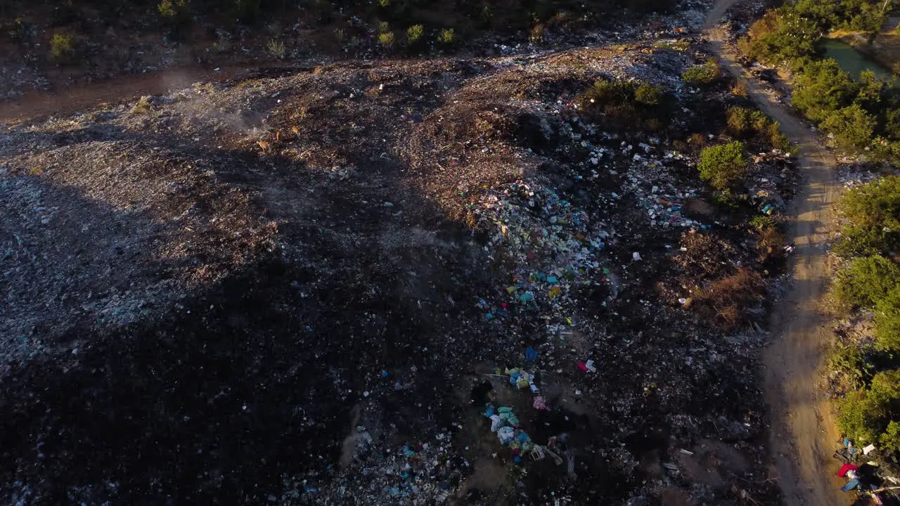 Huge mountains of plastic waste dumped in the middle of Cambodia's nature while part of it still smokes after being burned