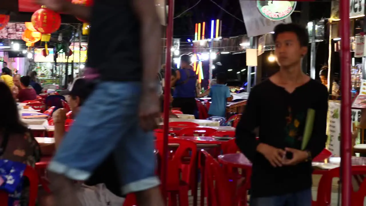 Night market food court and tourists with waiters serving and ready to serve