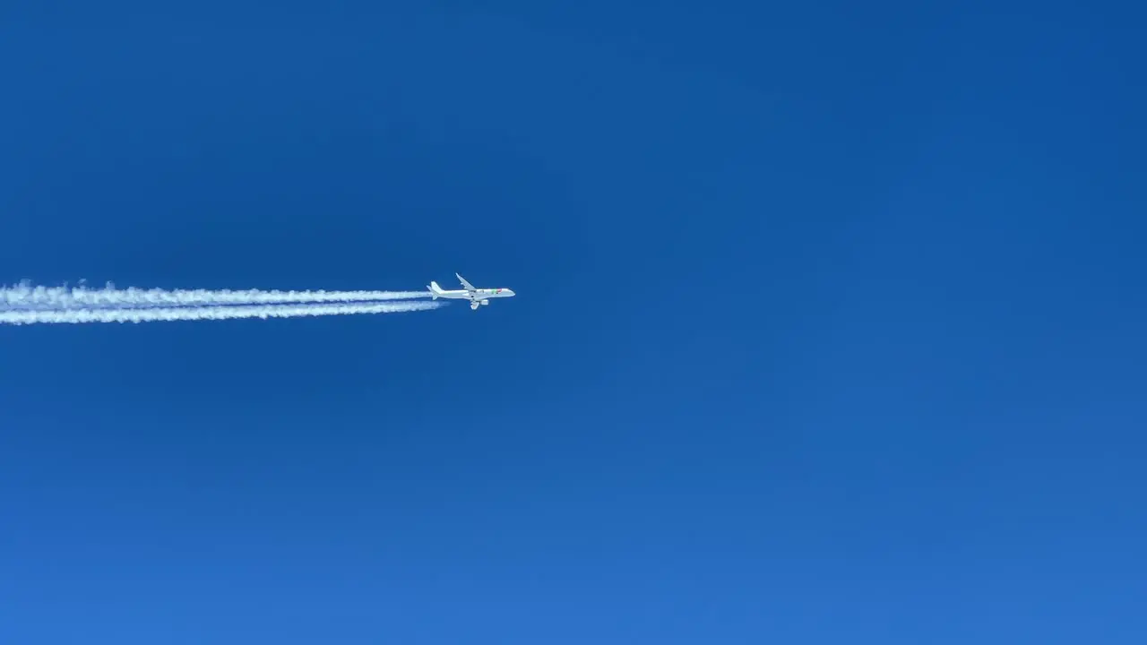 White jet airplane from TAP airlines shot from another jet cabin fliying parallel same track