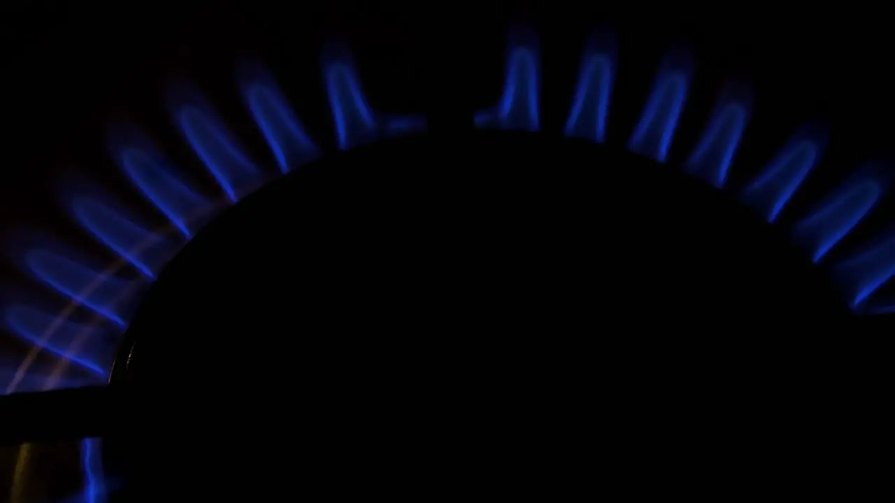 Gas burning from a kitchen gas stove dark background cold winter and energy crisis concept top down closeup shot