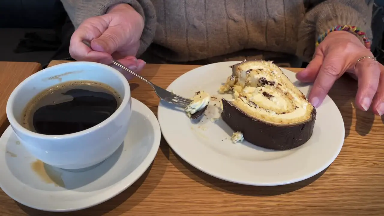 Elderly hands eating cake with coffee