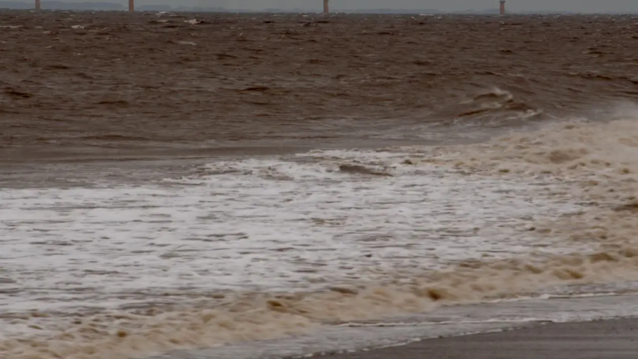 wide shot of cold bleak looking winter waves breaking on to Ingoldmells Skegness sandy beach