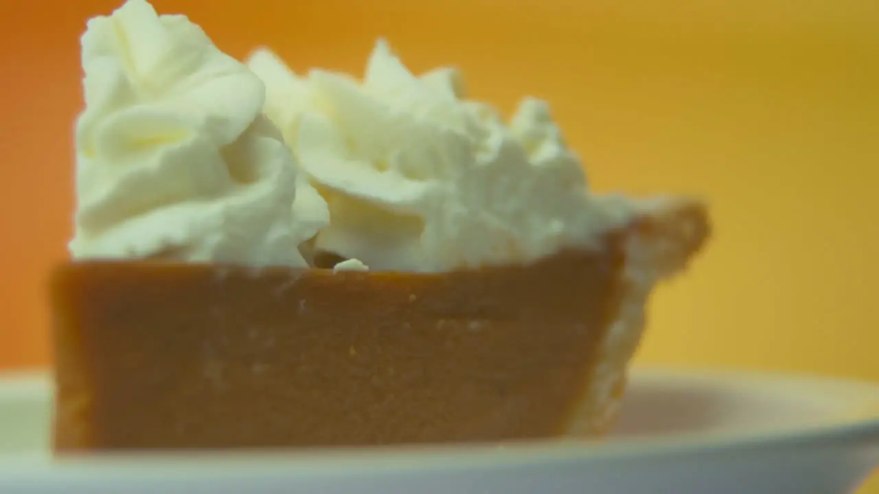 [Camera Used Canon C300] Macro pan left low angle rack focus pumpkin pie slice with whipped cream