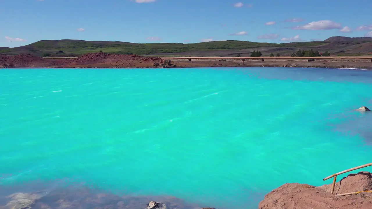 Vivid volcanic blue water behind the active volcano of Krafla in Myvatn Iceland Signs warn of dangerous conditions