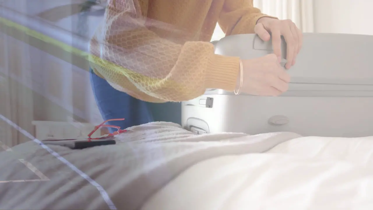 Animation of caucasian woman closing suitcase in bedroom over train at station