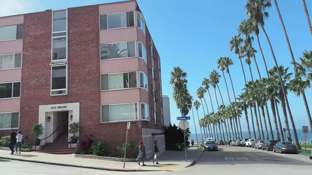 Street in La Jolla with palm trees coastal ocean view buildings and people