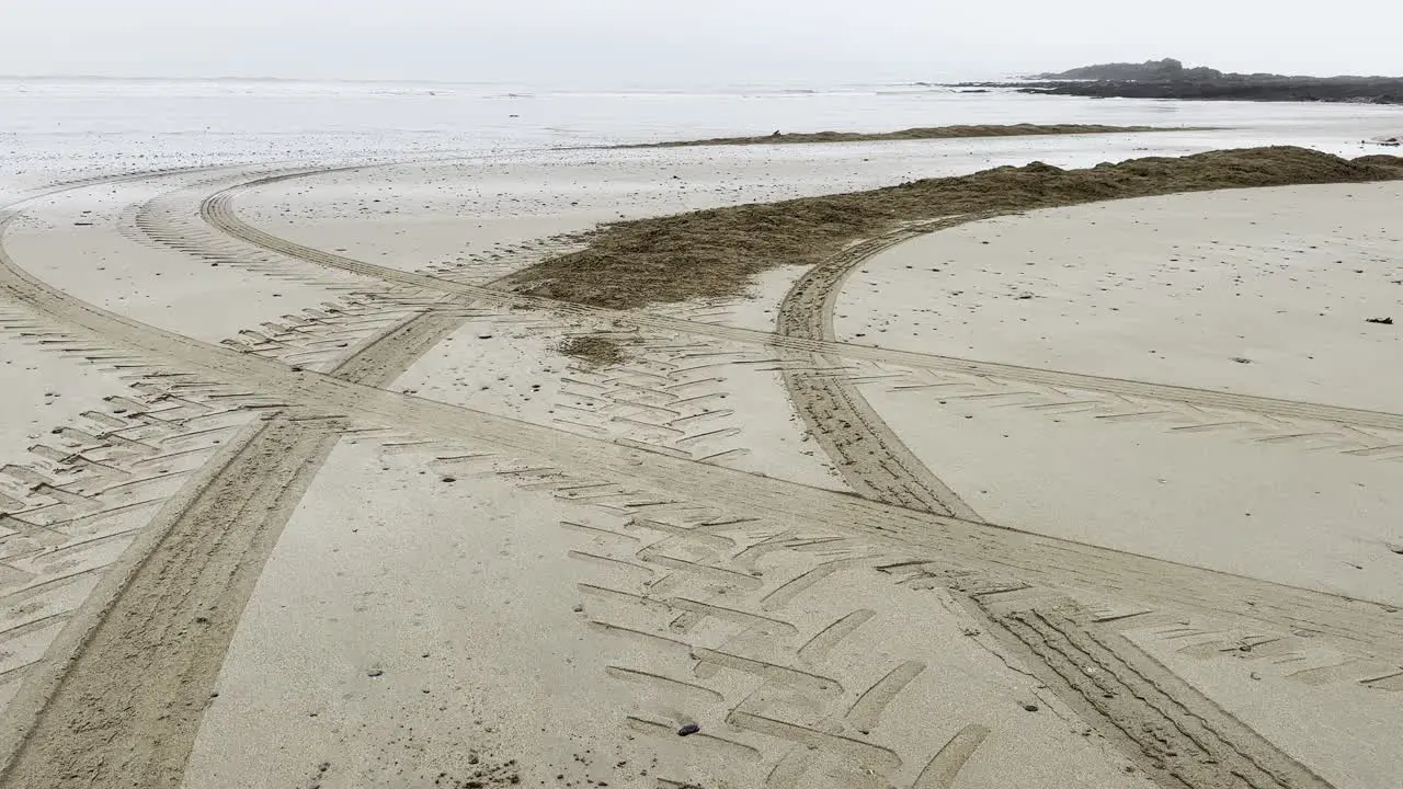 Fogy morning with tractor tracks on a sandy beach in Ireland