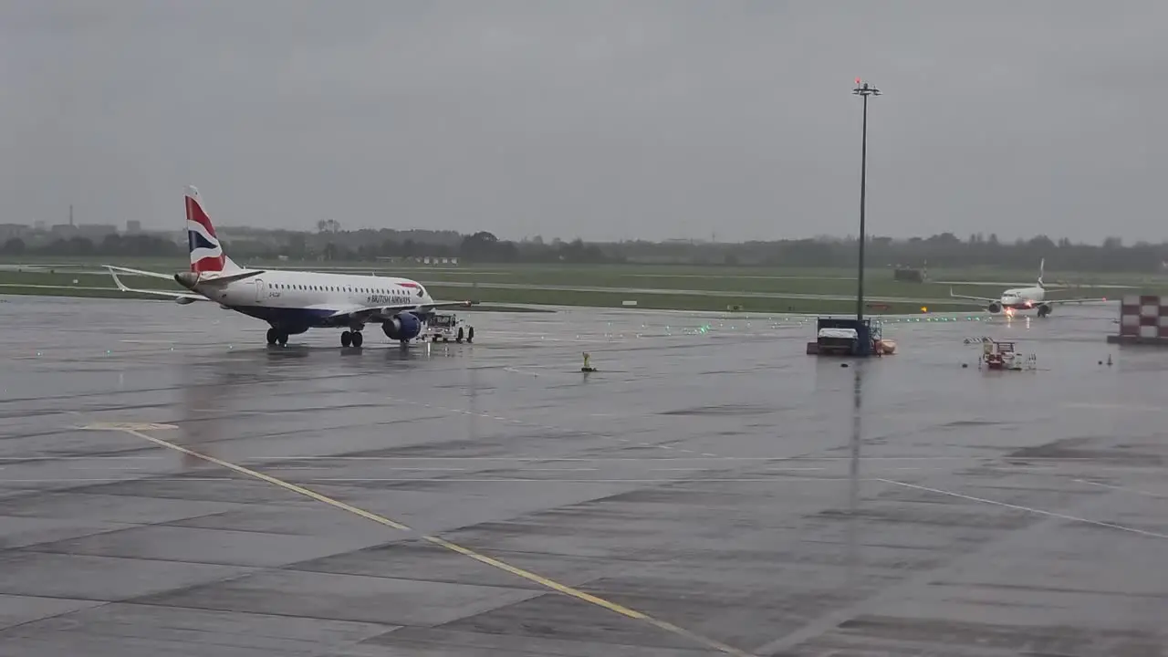 Dublin Airport Departures aeroplane taxiing on the runway with ground crews in bad weather