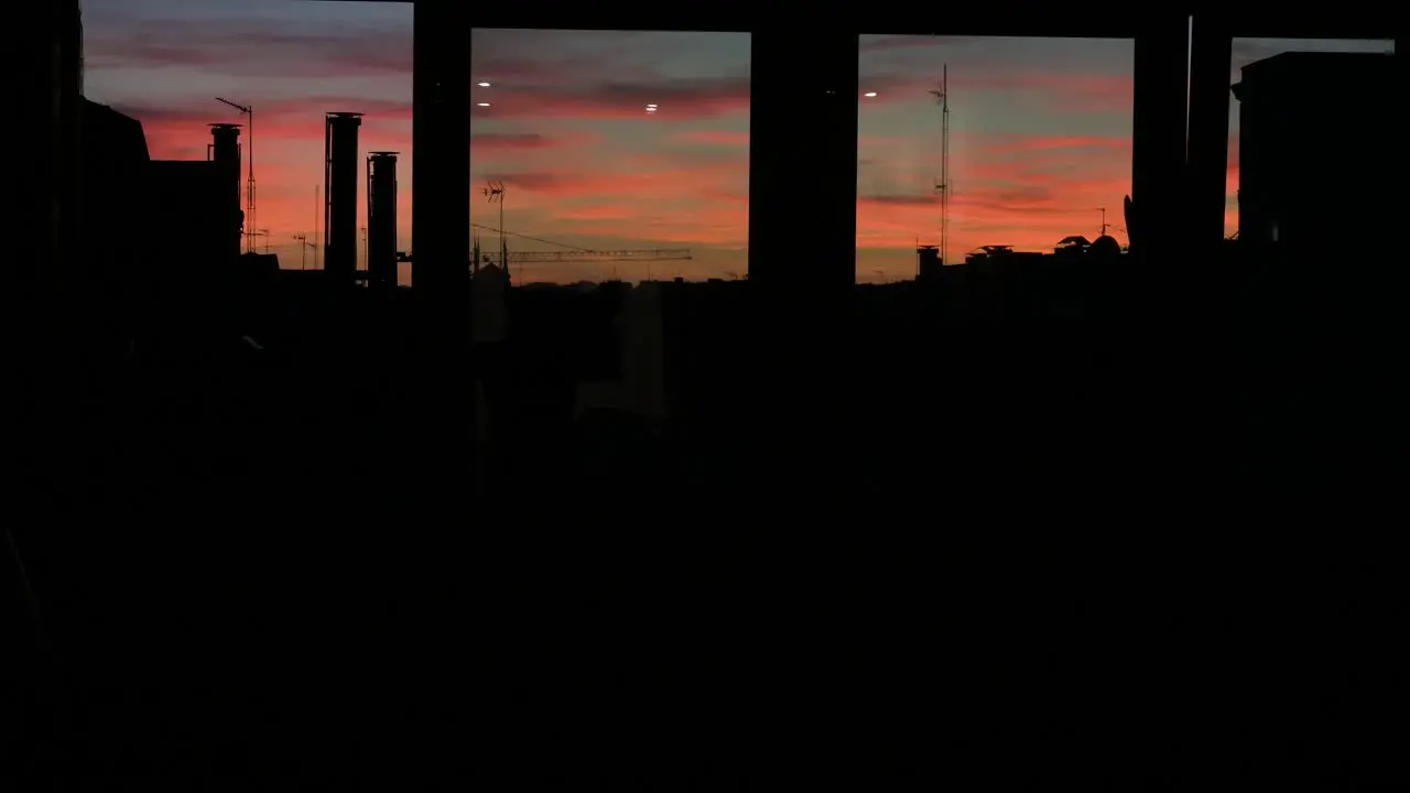 A see-through home window view of a beautiful soft color palette Summer sunset and sky seen in downtown Madrid Spain