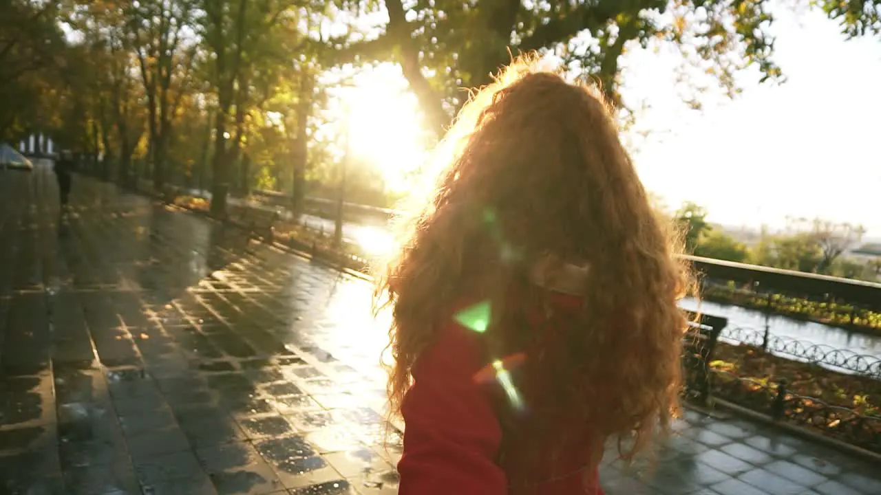 Young Womanwalking In A Colorful Autumn Park By Wet Alley Enjoying Autumn Foliage Turns Around Joyfully Smiling At Camera