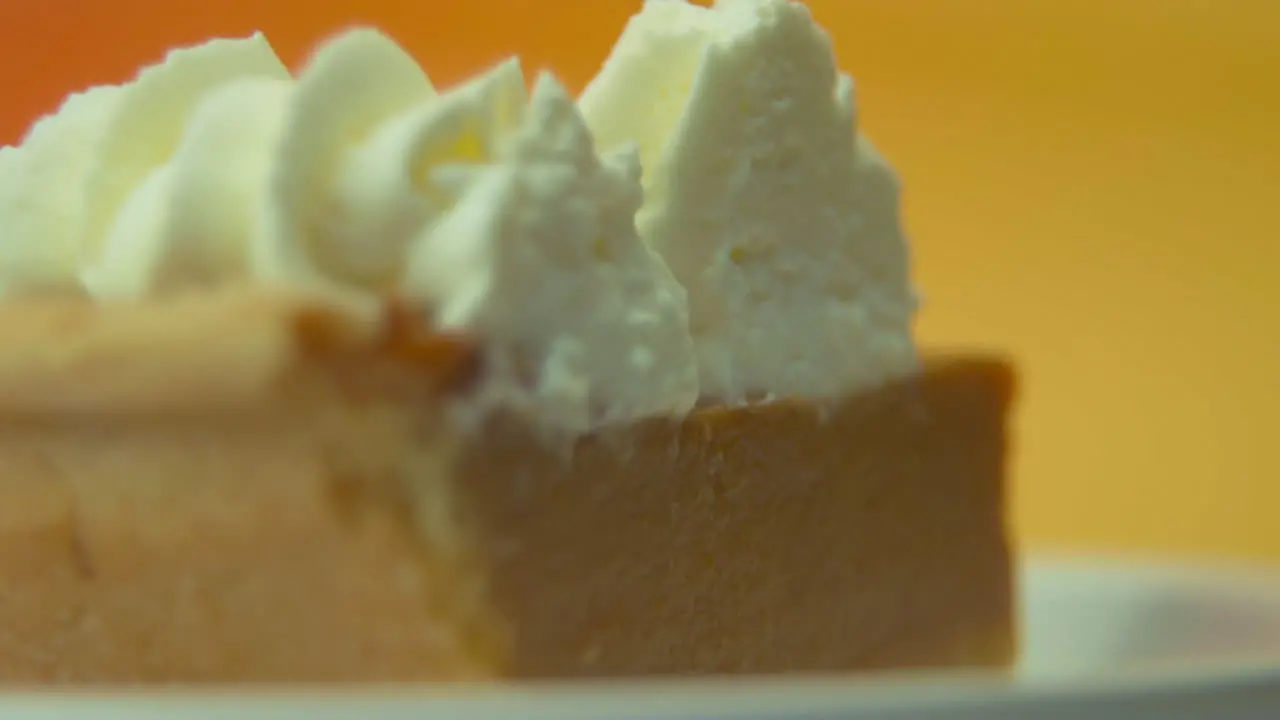 [Camera Used Canon C300] Macro static shot rack focus pumpkin pie slice loaded with fluffy whipped cream