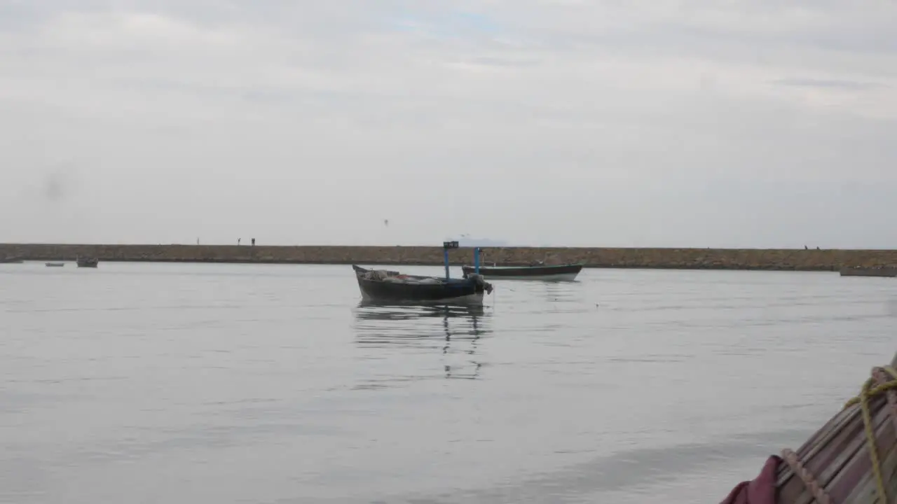 Dolly Left Reveal Of Small Empty Boat Floating In Harbour Waters In Gwadar On Coast Of Balochistan