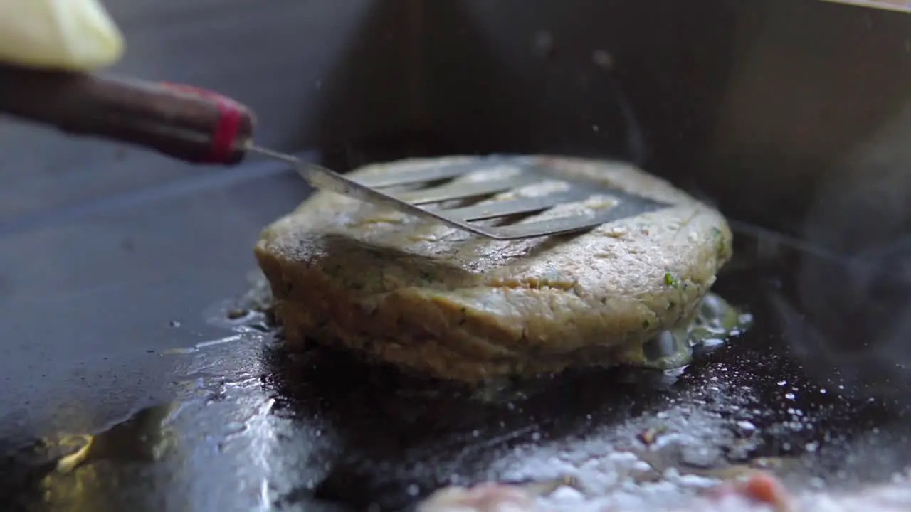 Burger is pushed down to the grill to be cooked properly