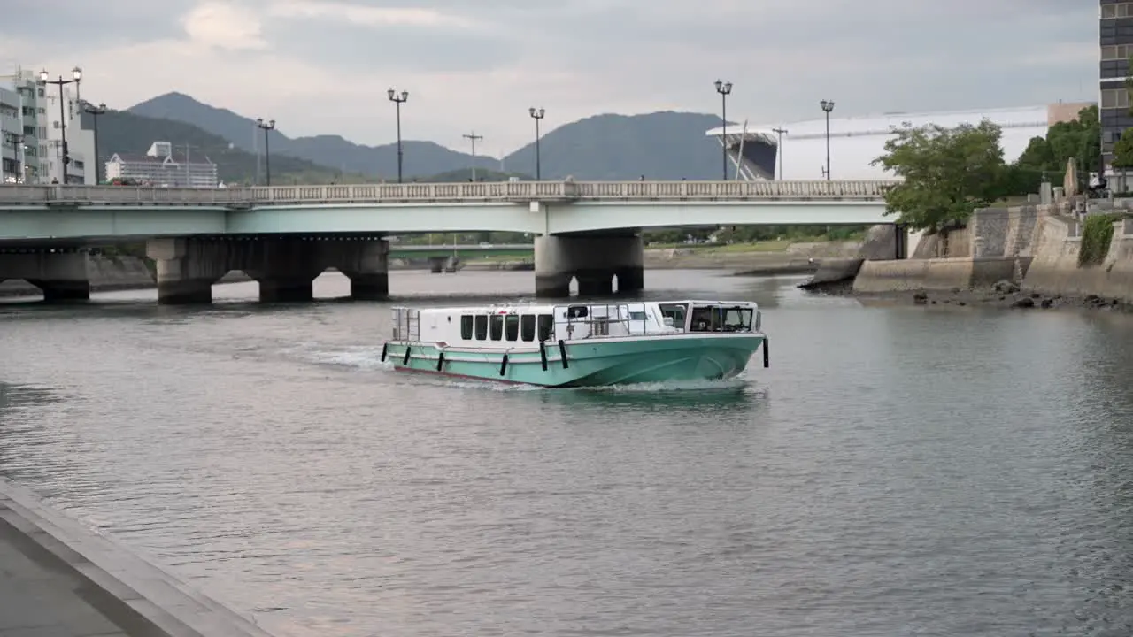 Aqua Net Ferry Boat Sailing Along Motoyasu River Past Atomic Bomb Dome In Hiroshima With Aioi Bridge In Background