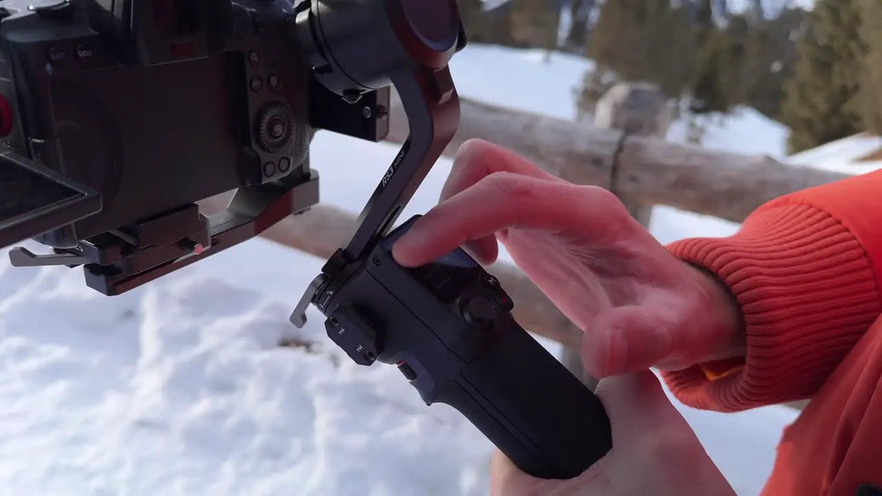 Close Up View Of Fingers Tapping On Gimbal Screen Outside With Snow On The Ground