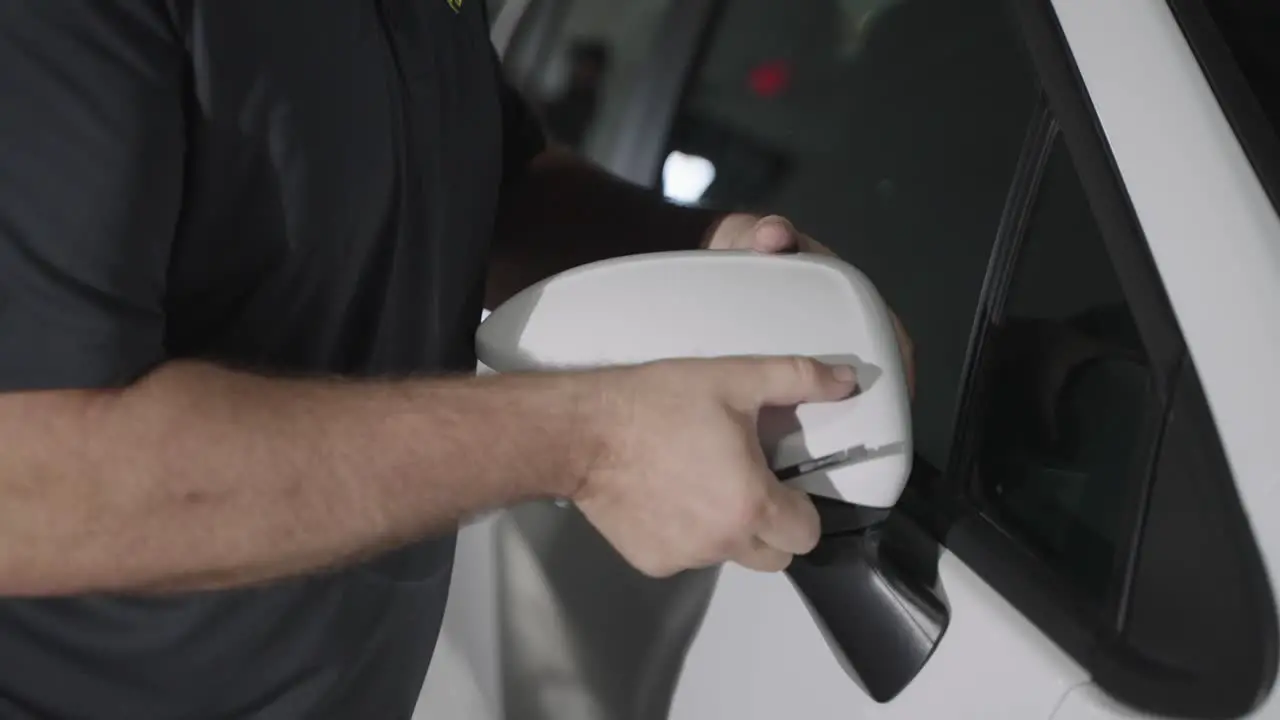 Unrecognizable mechanic removing car side mirror cap during repair slow motion