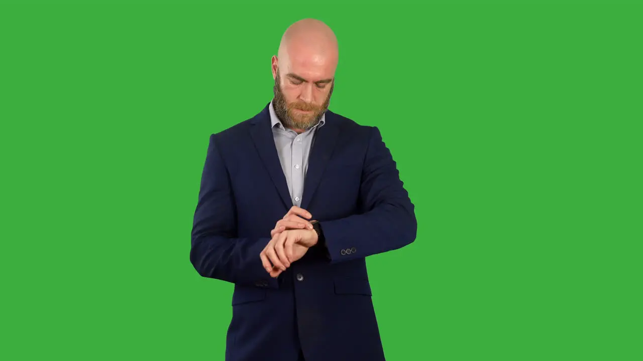 A businessman looking at a message notification on his smart watch on green screen