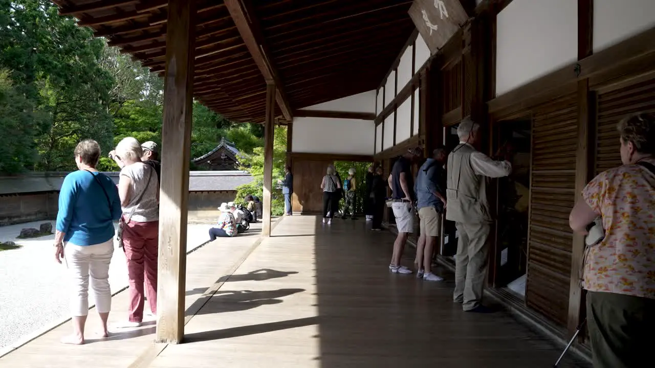 Foreign Tourists On Veranda At Ryoanji Temple On Sunny Day