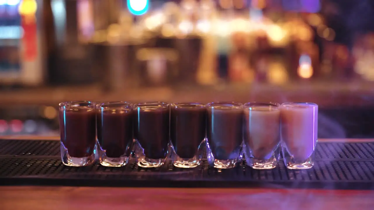 colorful shot drinks with smoke on the bar table