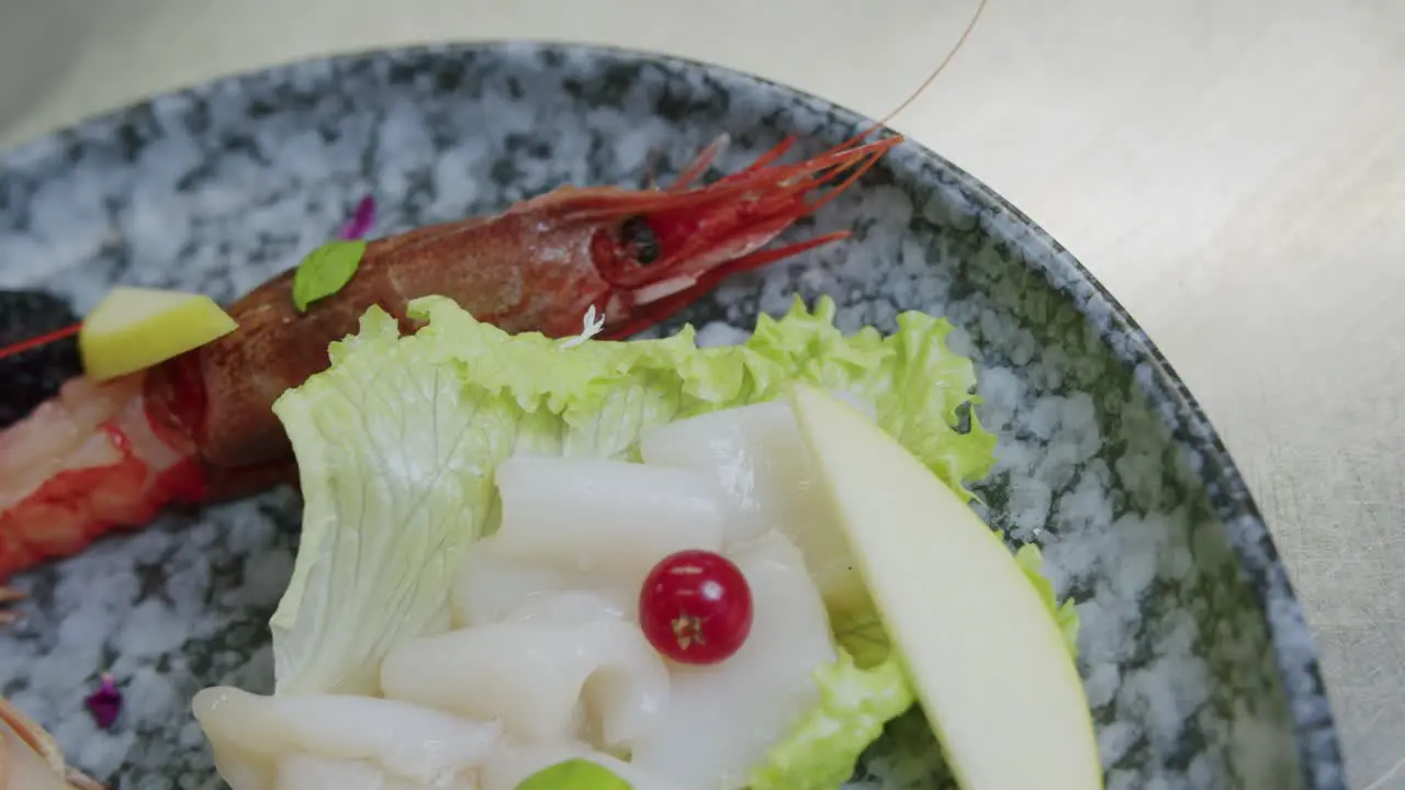 Macro shot of a dish full of scampi salat and fish 01