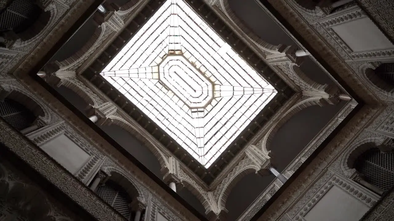 Looking up rotating shot looking up towards glass window ceiling with symmetrical architecture