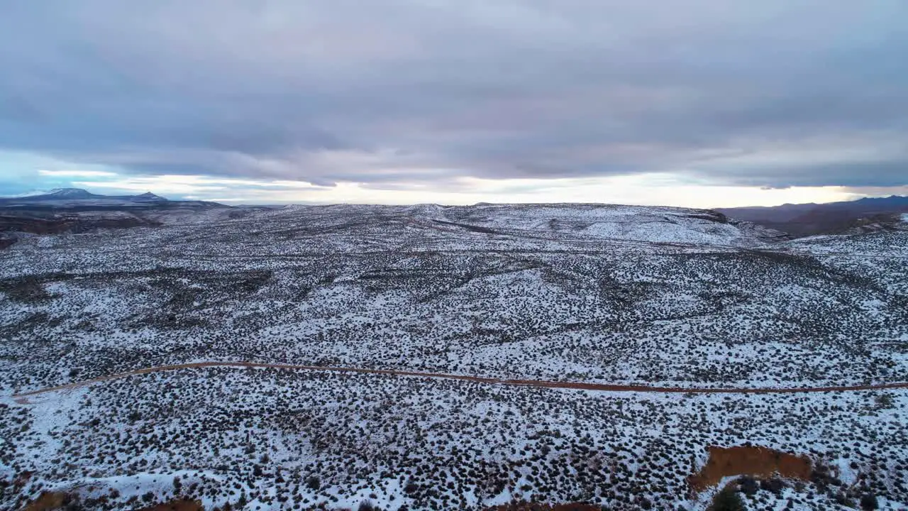 Aerial drone shot over the snowy desert on a cloudy day in Utah