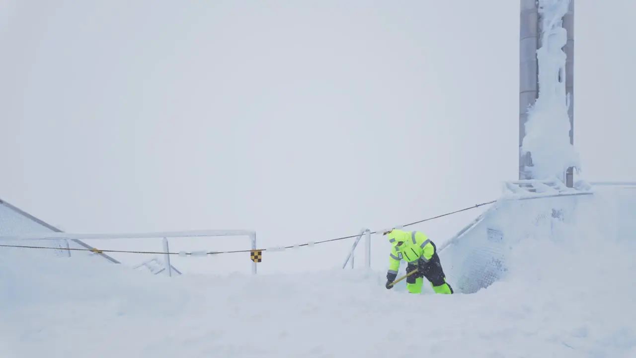 Worker Shoveling Snow Off Building Stairway On Zugspitze Mountain In Germany