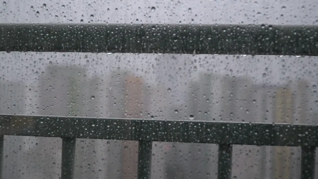 Water droplets on transparent window with skyscrapers in background bokeh