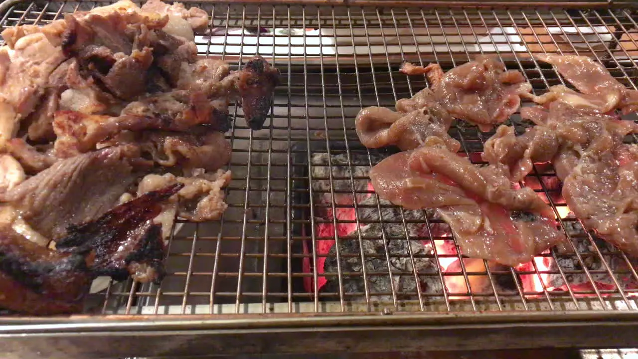 Traditional Korean BBQ beef bulgogi and pork belly are grilled on an open charcoal grill table-side at a restaurant