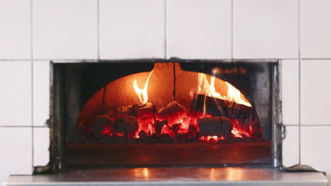 Close up of wood burning in the clay oven at an artisan bakery front view