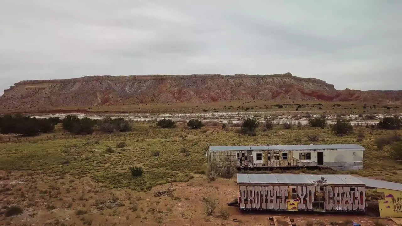 Drone flight over abandoned trailers with graffiti on them on the side of the highway