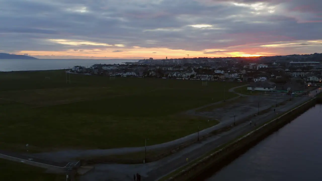 Rising aerial over sunrise on south park and Nimmo's pier as sun begins to cast golden glow over Claddagh Galway Ireland