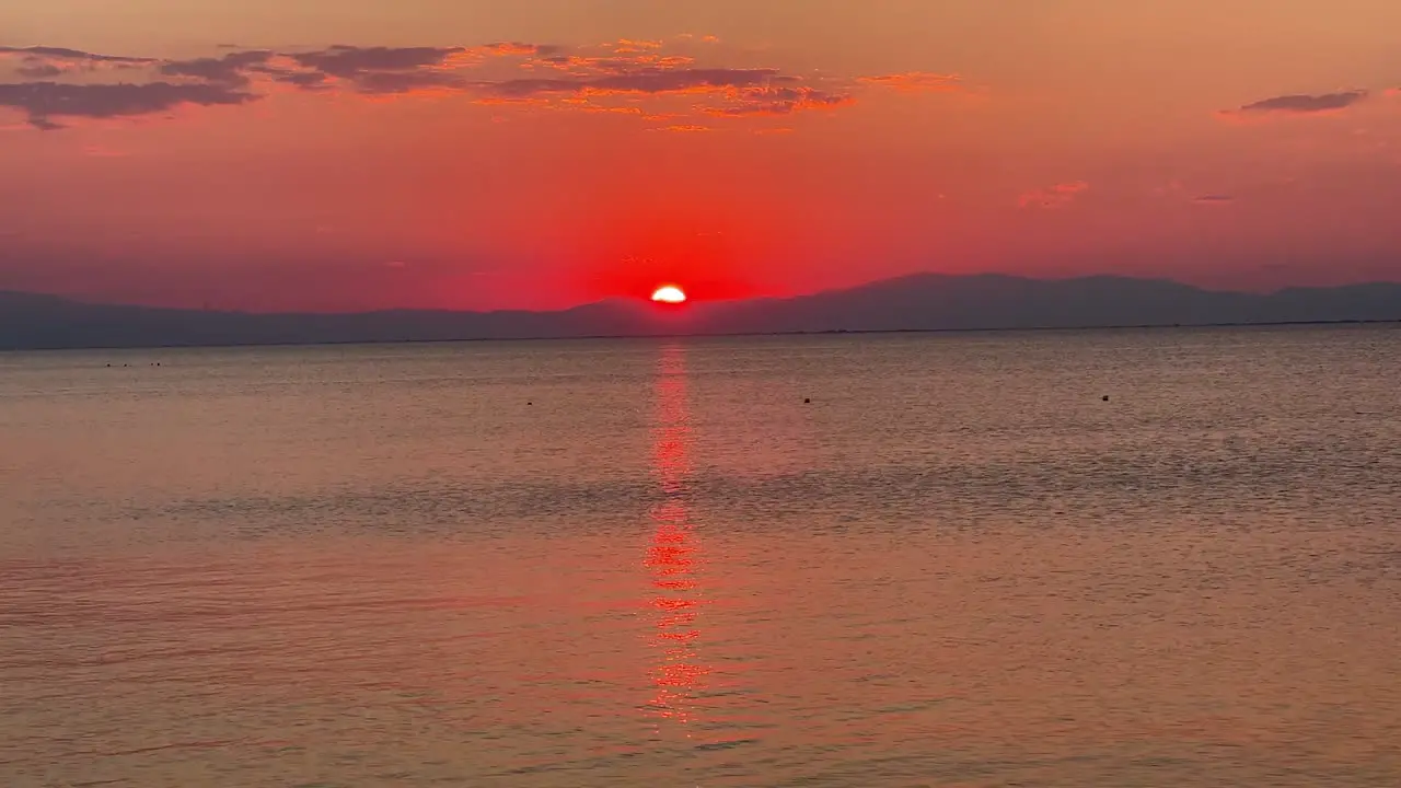 Beautiful golden red sunset over the mountain with a sun path over the sea