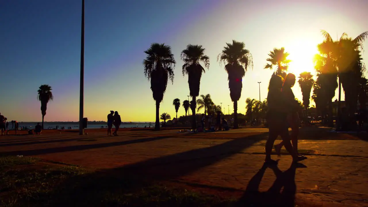 Silhouette of people walking on ocean side broadwalk during sunset in Brasilia Brazil