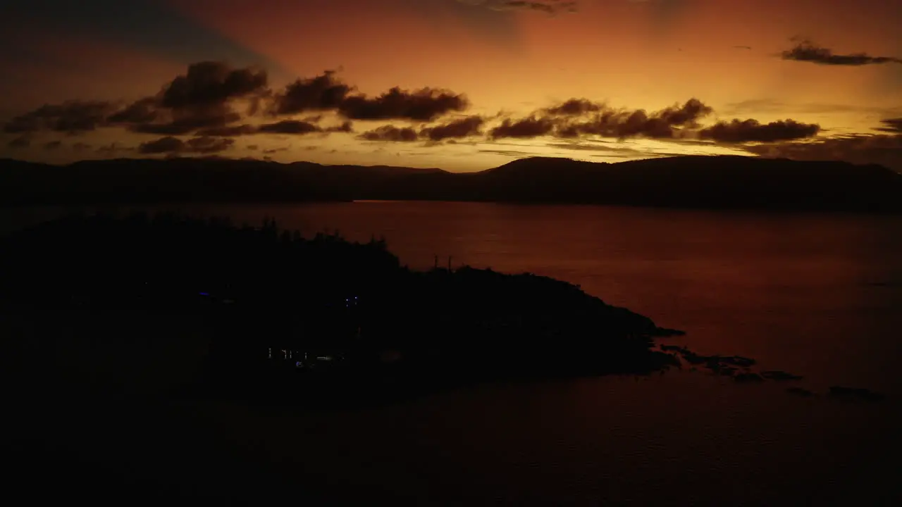 Pan up shot to reveal sunset with bright orange sky and clouds