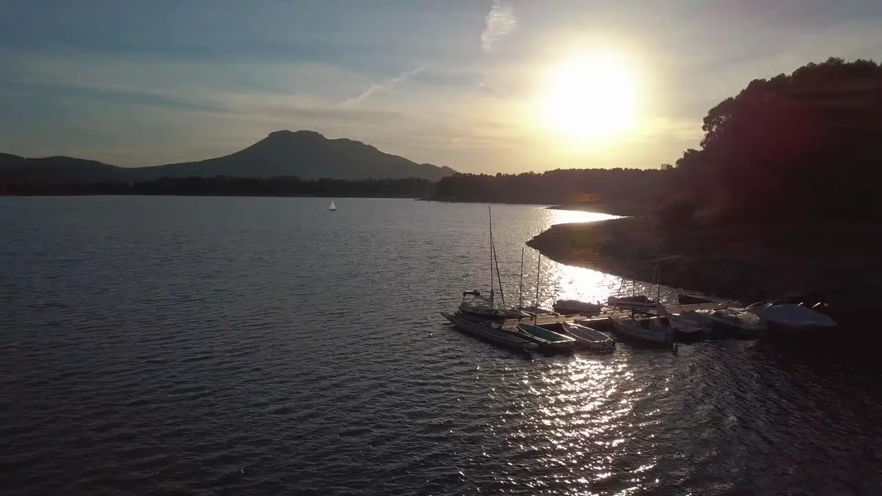 Aerial view of a sunset over a pier with boats in a lake of the south of Spain