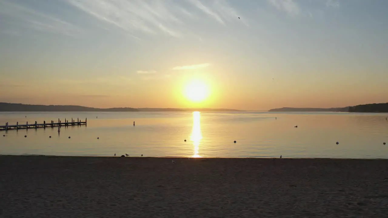 Filming during golden hour with a drone over looking the lake and sunset from the beach